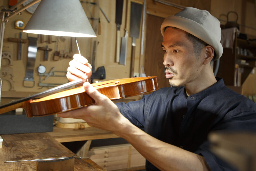 楽器の駒付近を確認する直井淳一郎